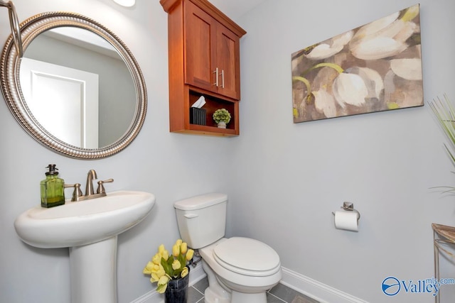 bathroom with toilet, tile patterned flooring, and baseboards