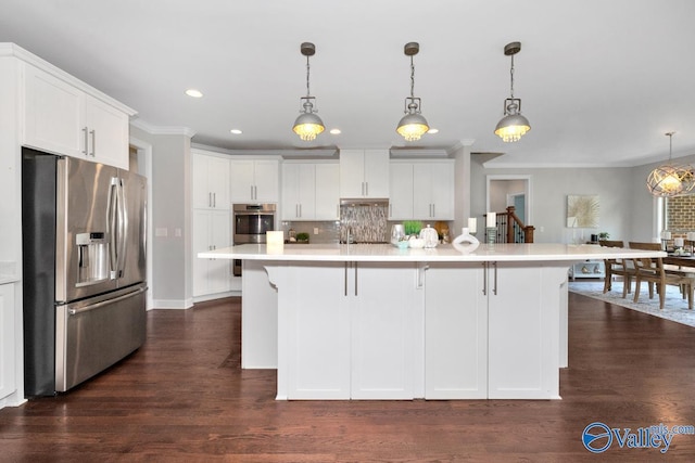 kitchen featuring stainless steel appliances, hanging light fixtures, and white cabinets