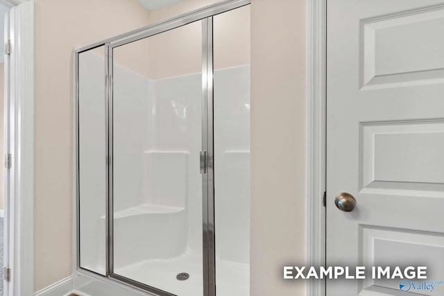 bathroom featuring a shower with shower door