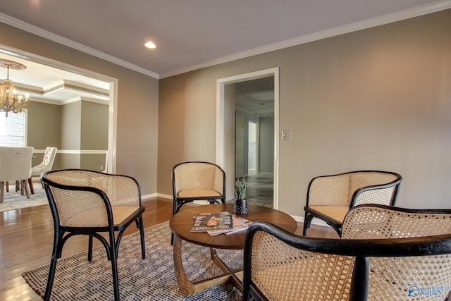 living area with recessed lighting, crown molding, wood finished floors, baseboards, and an inviting chandelier