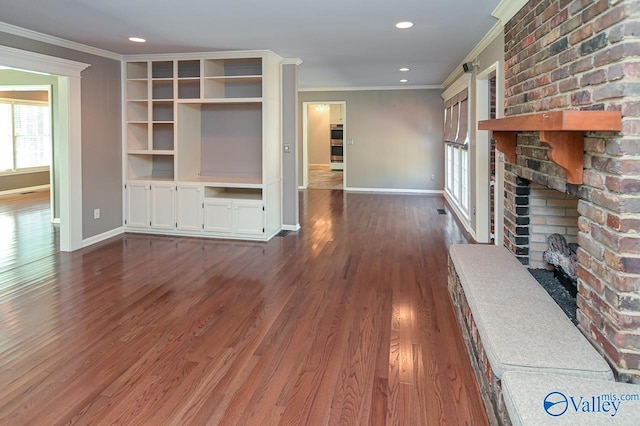 unfurnished living room featuring baseboards, wood finished floors, crown molding, a fireplace, and recessed lighting