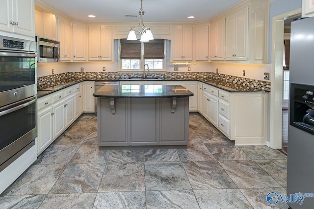 kitchen featuring a kitchen island, stainless steel appliances, a sink, and recessed lighting