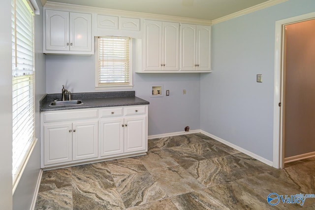 clothes washing area with cabinet space, baseboards, ornamental molding, washer hookup, and a sink