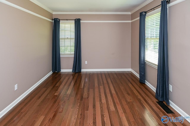 unfurnished room with baseboards, visible vents, wood finished floors, and ornamental molding