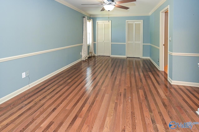 unfurnished bedroom with baseboards, a ceiling fan, wood finished floors, crown molding, and multiple closets