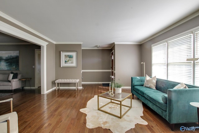 living area featuring crown molding, baseboards, and wood finished floors