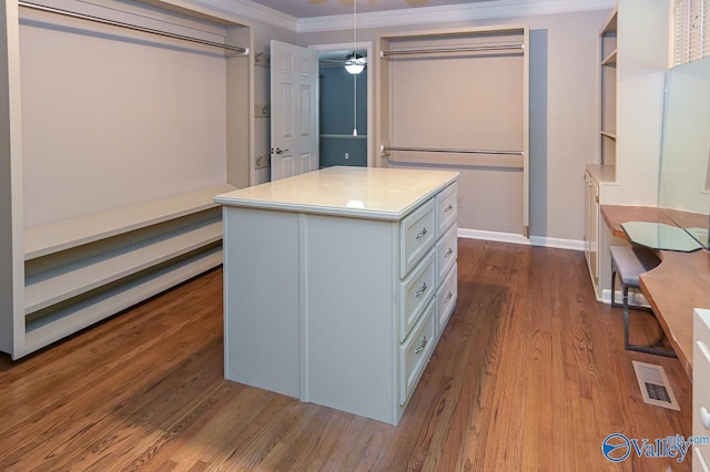 spacious closet featuring visible vents, ceiling fan, and wood finished floors