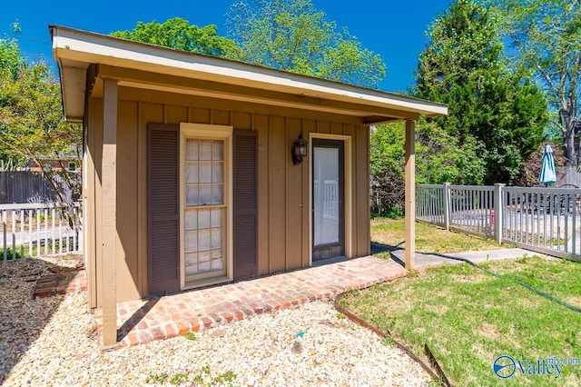 view of outbuilding featuring fence and an outbuilding