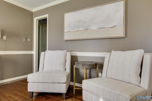 living area featuring ornamental molding, baseboards, and wood finished floors