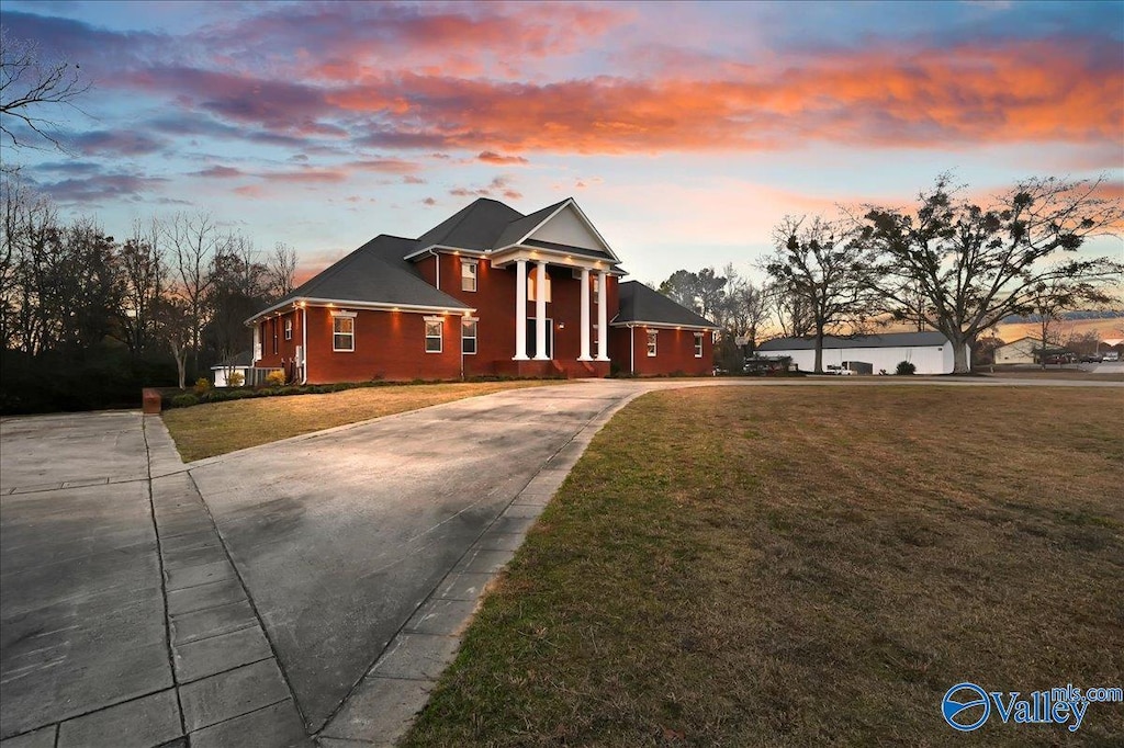 neoclassical home featuring a lawn