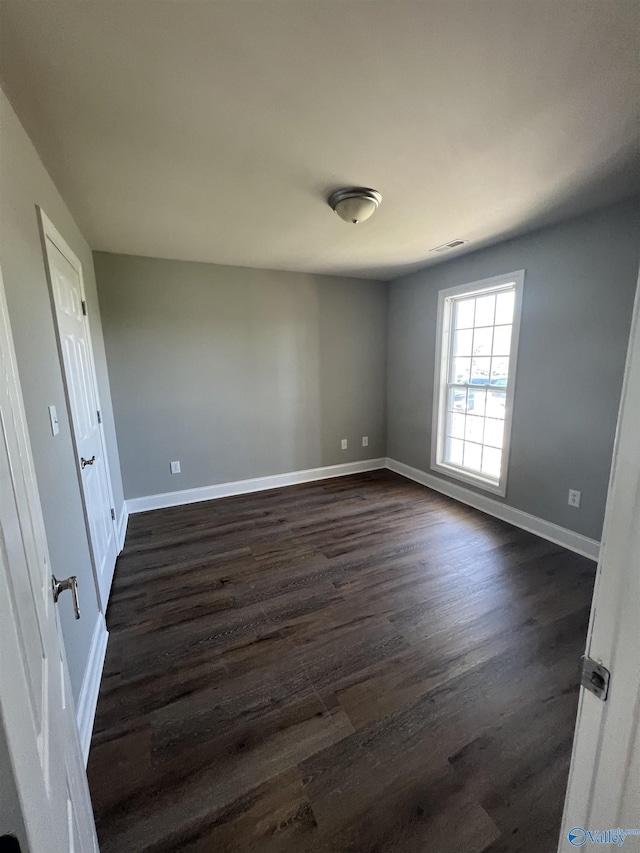 empty room with dark hardwood / wood-style flooring