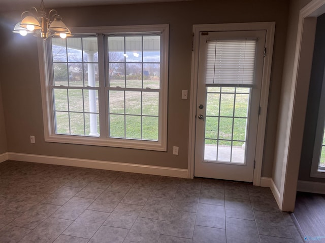 doorway with light tile patterned floors and a notable chandelier