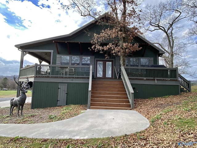 view of front of home featuring a deck, french doors, and stairway