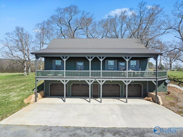 view of front facade featuring metal roof, a front lawn, an attached garage, and driveway