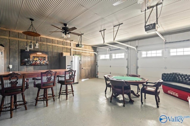 garage featuring fridge with ice dispenser and a garage door opener