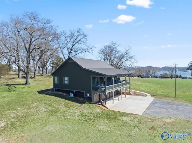 view of home's exterior with a yard, driveway, and a patio