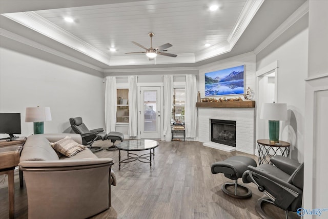 living room featuring a brick fireplace, hardwood / wood-style flooring, a raised ceiling, and wooden ceiling