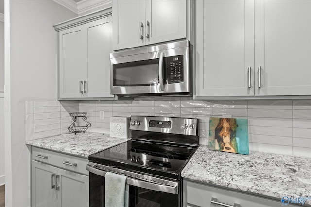 kitchen with backsplash, light stone countertops, and appliances with stainless steel finishes