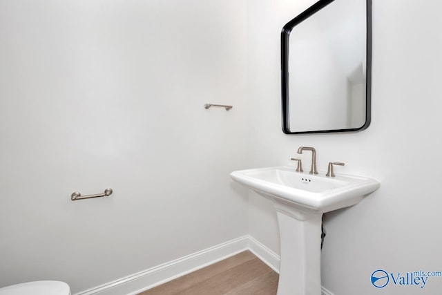 bathroom featuring hardwood / wood-style flooring and toilet