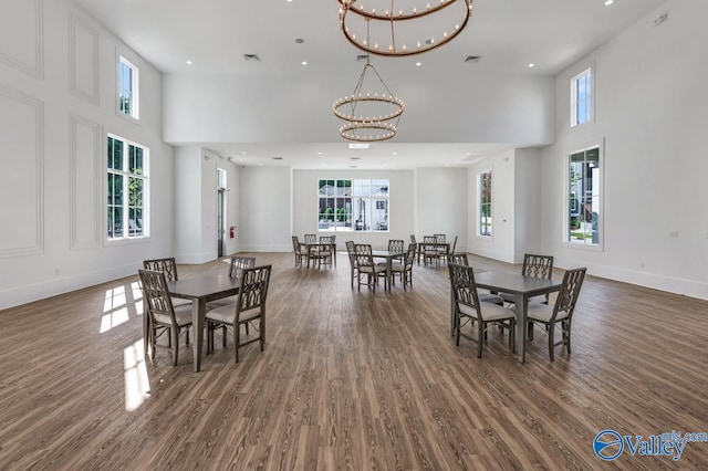 dining area featuring a high ceiling, dark hardwood / wood-style floors, and a chandelier