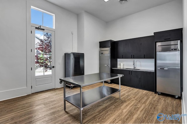 kitchen with sink, stainless steel fridge, and light hardwood / wood-style flooring