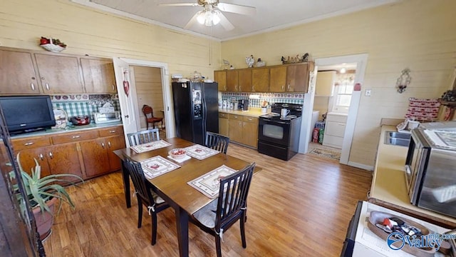 kitchen featuring tasteful backsplash, ceiling fan, light wood-type flooring, and black appliances