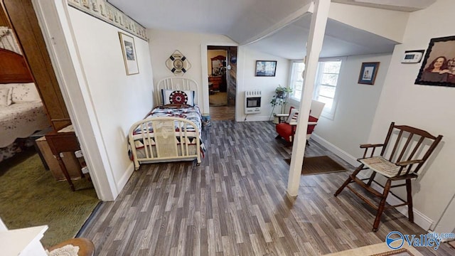 bedroom featuring hardwood / wood-style flooring, vaulted ceiling, and heating unit