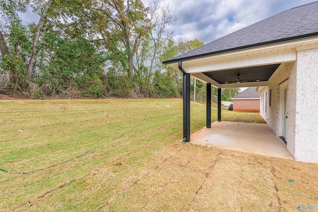 view of yard with ceiling fan and a patio area