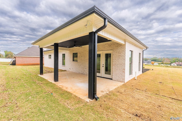 back of house with french doors, ceiling fan, a patio area, and a lawn