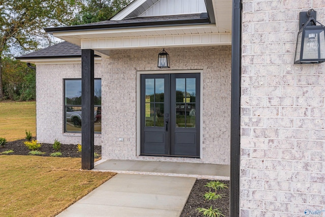 view of exterior entry featuring a yard and french doors