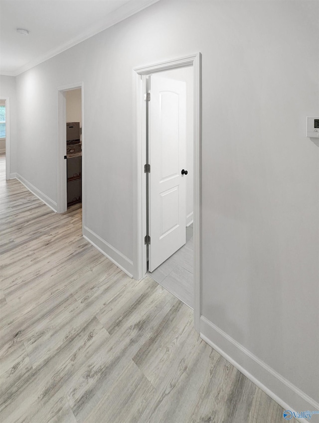 hallway featuring crown molding and light wood-type flooring