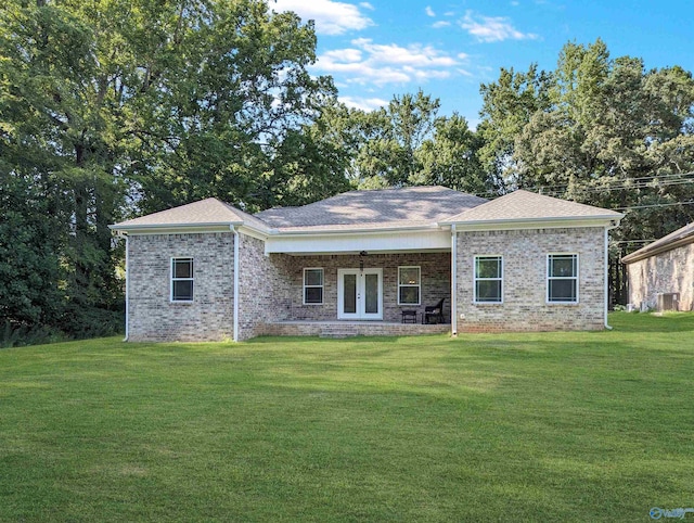 rear view of property featuring french doors, central AC unit, and a lawn