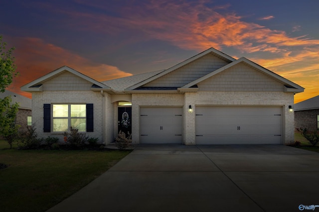 view of front of home with a garage and a lawn