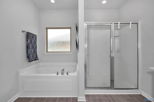 bathroom featuring plus walk in shower and hardwood / wood-style flooring