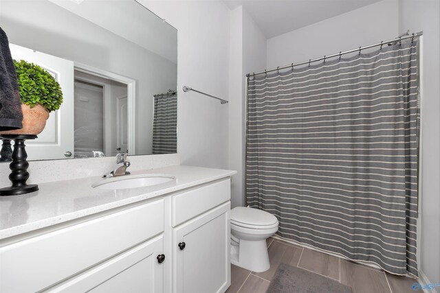 bathroom with vanity, toilet, a shower with curtain, and hardwood / wood-style flooring