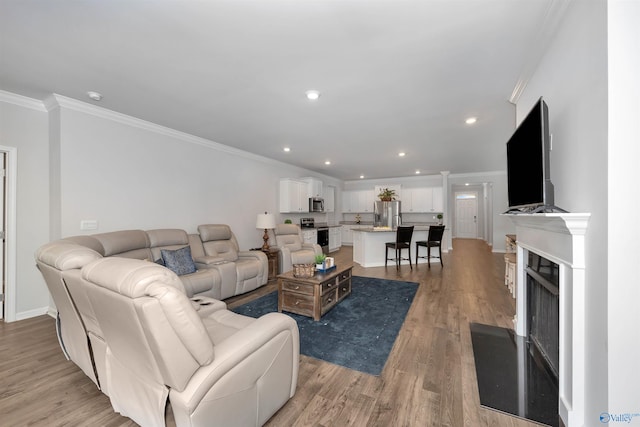 living room featuring ornamental molding and light hardwood / wood-style flooring