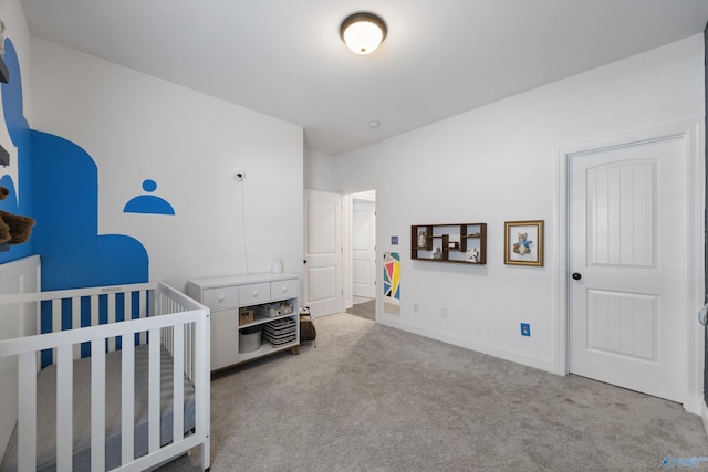 bedroom with a crib and light colored carpet