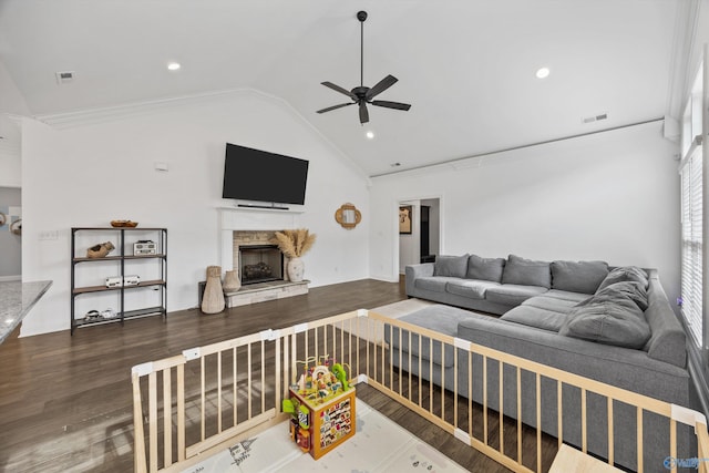 living room with vaulted ceiling, dark hardwood / wood-style flooring, ceiling fan, and a fireplace