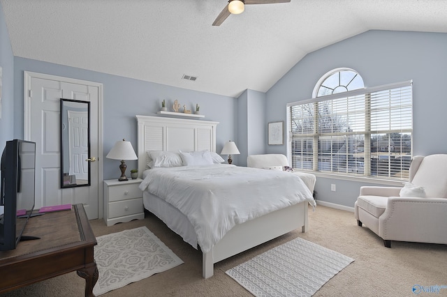 bedroom featuring ceiling fan, lofted ceiling, light colored carpet, and a textured ceiling