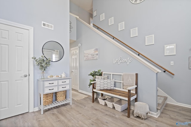 staircase with hardwood / wood-style flooring and a high ceiling