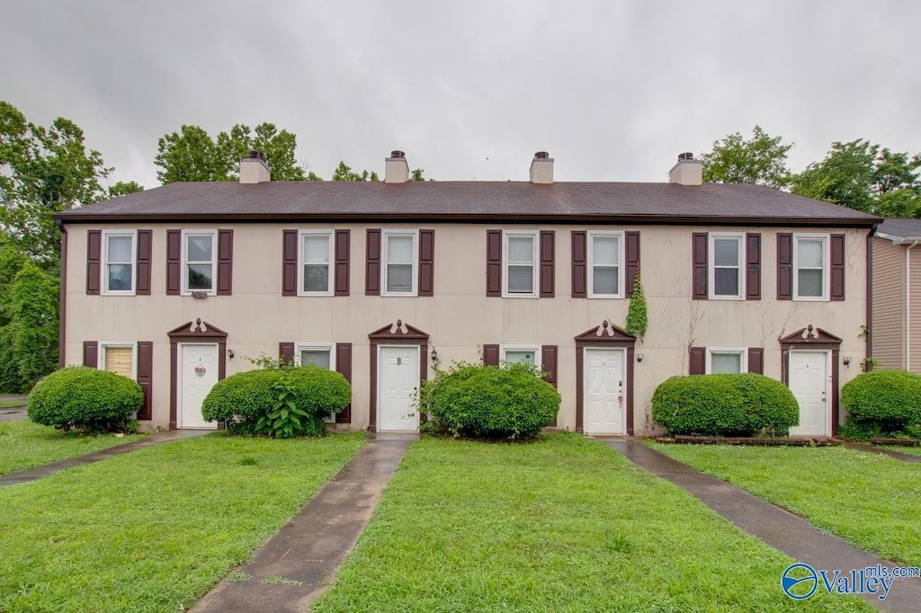 2613 Wynterhall Rd, Huntsville, AL 35803 - view of front of home featuring a chimney, a front yard, and stucco siding