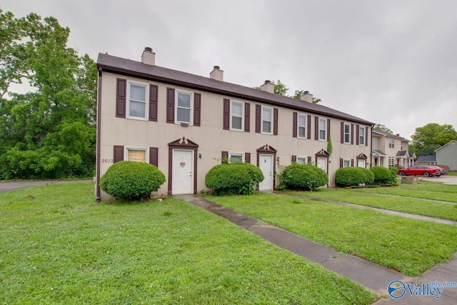 2613 Wynterhall Rd, Huntsville, AL 35803 - view of front facade with a chimney, a front yard, and stucco siding
