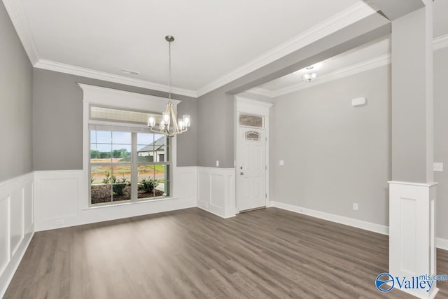 unfurnished dining area with ornamental molding, dark wood-type flooring, and an inviting chandelier