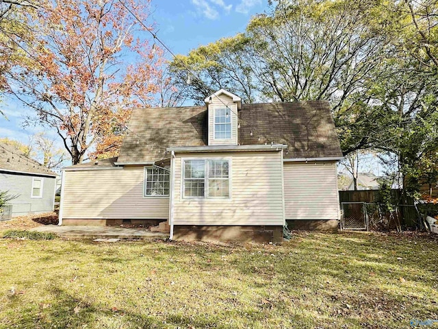 rear view of property featuring a lawn