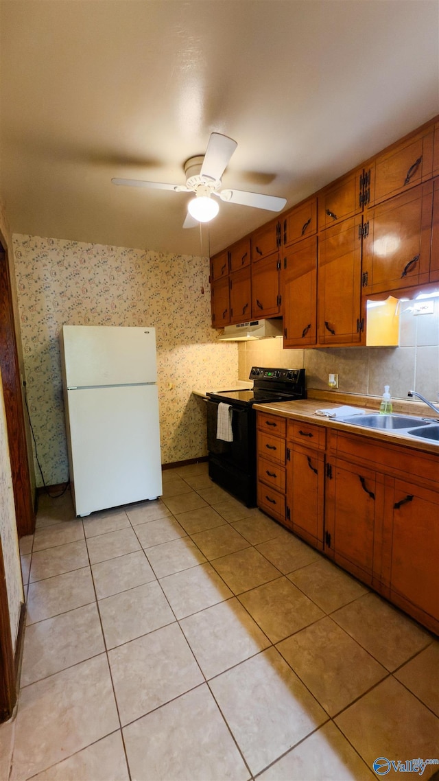 2808 Elmore Rd, Huntsville, AL 35805 - kitchen featuring freestanding refrigerator, black range with electric stovetop, brown cabinets, under cabinet range hood, and ceiling fan