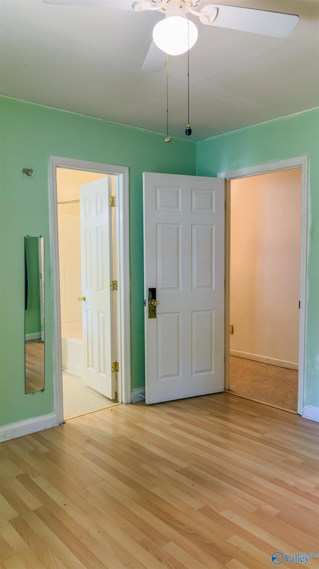 2808 Elmore Rd, Huntsville, AL 35805 - unfurnished bedroom with light wood finished floors, baseboards, ensuite bathroom, and ceiling fan