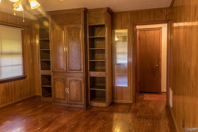 2808 Elmore Rd, Huntsville, AL 35805 - unfurnished bedroom with dark wood finished floors, wooden walls, baseboards, a textured ceiling, and ornamental molding
