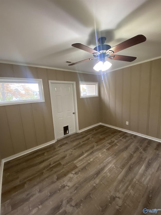 unfurnished room with plenty of natural light, dark wood-type flooring, and ceiling fan