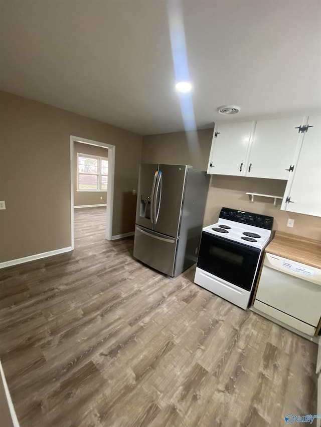 kitchen with white cabinets, light hardwood / wood-style floors, and white appliances