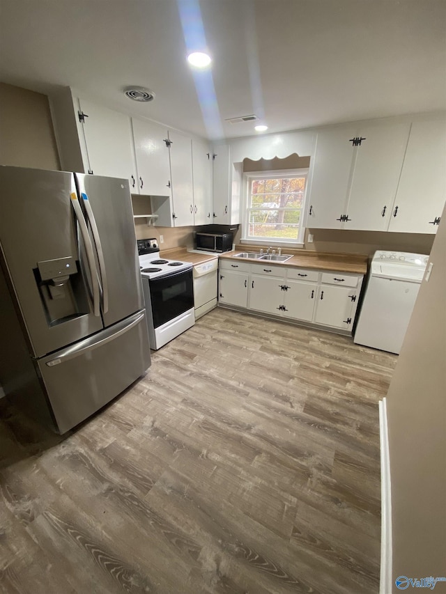 kitchen featuring white cabinetry, white appliances, sink, and light hardwood / wood-style flooring